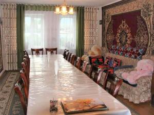 a dining room with a large table and a couch at Guest House Nur in Kochkorka