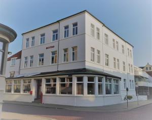 a large white building with windows on a street at Villa Westend in Norderney
