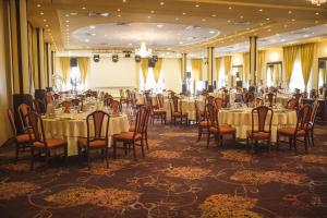 a banquet hall with tables and chairs in a room at Hotel Astoria in Alba Iulia