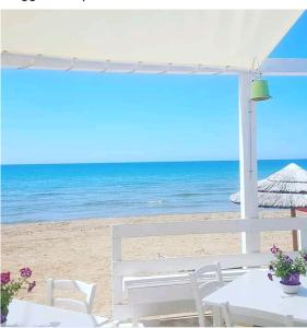 un tavolo e sedie su una spiaggia con l'oceano di VILLA ANTONY a Granelli