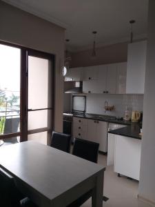 uma cozinha com armários brancos e uma mesa com cadeiras em Apartment Gorgiladze 66 em Batumi