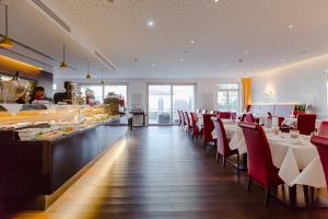 uma sala de jantar com cadeiras vermelhas e um buffet em Aqua Aurelia Suitenhotel an den Thermen em Baden-Baden