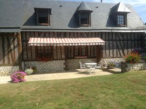 una casa con patio y mesa en el patio en Chambres d'Hôtes Le Pressoir, en Saint-Martin-de-Boscherville