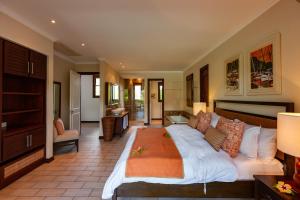 a bedroom with a large bed and a living room at Eden Confort in Eden Island
