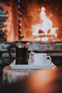 a cup of coffee on a plate on a table at Kuerkievari KuerHostel in Äkäslompolo
