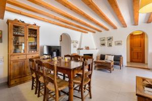 uma sala de jantar com uma mesa de madeira e cadeiras em Villa Romero II em Es Cubells