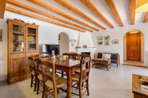 a dining room with a wooden table and chairs at Villa Romero II in Es Cubells