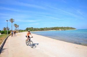 a man riding a bike on the beach at Apartments Karolina in Novalja