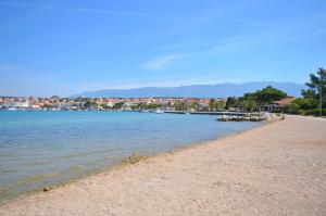 a view of a beach with houses in the background at Apartments Karolina in Novalja