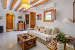 a living room with a couch and a table at Villa Romero II in Es Cubells