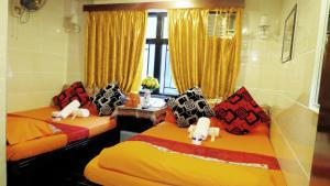 two beds in a room with yellow and red at Pacific Lodge Reception 10th Floor Block D in Hong Kong