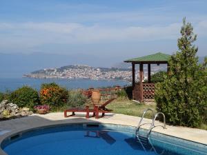 einen Pool mit einer Bank und einem Pavillon in der Unterkunft villa Marija in Ohrid