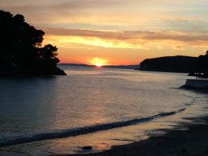a sunset on a beach with the ocean at ANEMOS in Parga