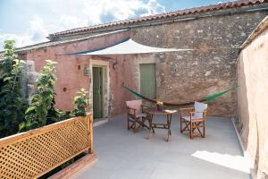 a patio with a table and chairs on a balcony at Lemon Tree Eco-Retreat in Gavalochori