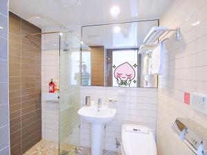 W łazience znajduje się umywalka, toaleta i lustro. w obiekcie Hotel Stay Interview Jeju w mieście Seogwipo