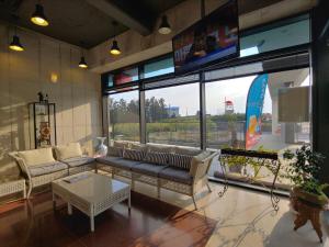 a living room with couches and a large window at Hotel Stay Interview Jeju in Seogwipo