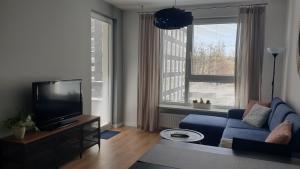 uma sala de estar com um sofá azul e uma televisão em Quo Vadis Apartment em Varósvia