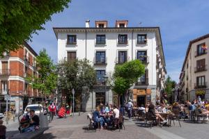 a group of people sitting at tables in front of a building at Apartamento TEMPORAL Diseño Chueca-Malasaña BRC40 in Madrid