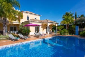 a house with a swimming pool in front of a house at Casa da Colina in Loulé