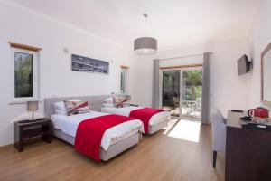 a bedroom with two beds and a tv and a window at Casa da Colina in Loulé +29 photos