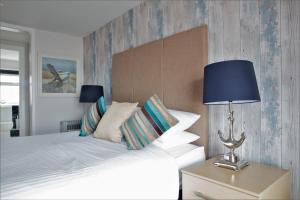 a bedroom with a bed with a blue lamp and pillows at The Two Lifeboats in Sheringham