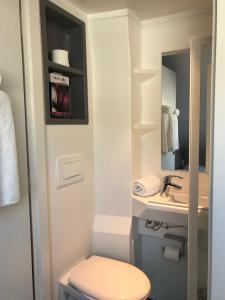 ein Badezimmer mit Toilette, Waschbecken und Spiegel in der Unterkunft Smart Living in Saint-Nazaire + 36 Fotos