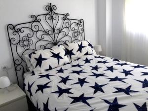 ein Schlafzimmer mit einem Bett mit blauen Sternen darauf in der Unterkunft Estupendo Apartamento HUELVA Flecha del Rompido in El Portil