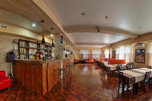 a restaurant with a bar and tables and chairs at Tukan Hotel in Krasnaya Polyana