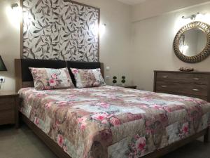 a bedroom with a bed and a mirror and a dresser at Politakis Apartment in Keramoti