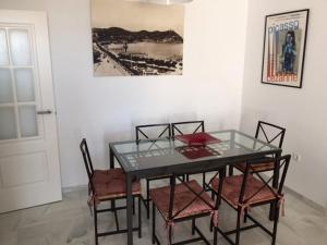 ein Esszimmer mit einem Glastisch und Stühlen in der Unterkunft Estupendo Apartamento HUELVA Flecha del Rompido in El Portil