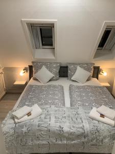 ビューズムにあるAn de Warft Appartement 9 Schwalbennestのベッドルーム1室(ベッド2台、枕、テレビ付)