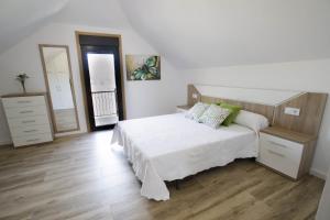 1 dormitorio con cama, tocador y espejo en Casa A Rotea en Vilaboa