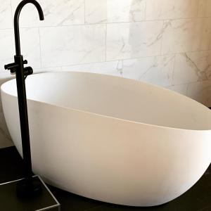 una vasca da bagno bianca seduta in bagno di Grenna Hotell a Gränna