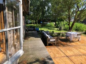 une terrasse couverte en bois avec un canapé et une table dans l'établissement Cabin in the Green - near Amsterdam, à Velsen-Zuid