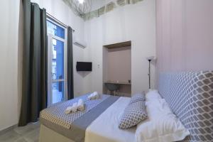 een slaapkamer met een bed en een groot raam bij Bell'eBBuono Suite in Napels
