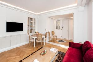 a living room with a red couch and a table at Luxury Montaigne apartment in Paris