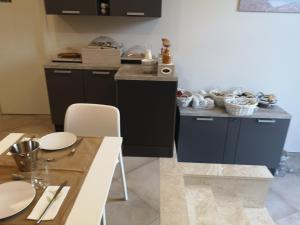 una cocina con armarios negros y una mesa con platos blancos en Hotel & Wellness Stella Delle Langhe, en Govone
