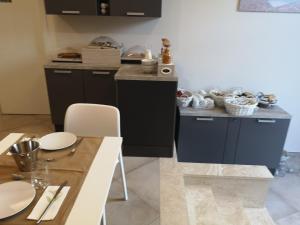 a kitchen with black cabinets and a table with white plates at Hotel & Wellness Stella Delle Langhe in Govone