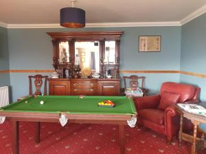 a living room with a pool table and a chair at Creag-Ard Bed & Breakfast in Dundonnell