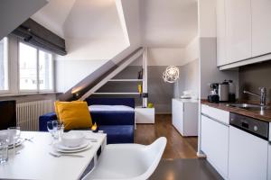 una cucina e un soggiorno con un tavolo e un divano di Residence Key Inn - Limperstberg a Lussemburgo
