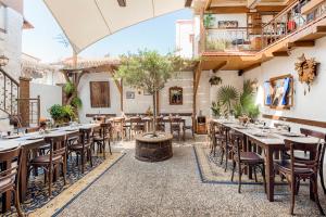 a restaurant with tables and chairs in a courtyard at Koukos Rodos Boutique Hotel & Spa - Adults Only in Rhodes Town