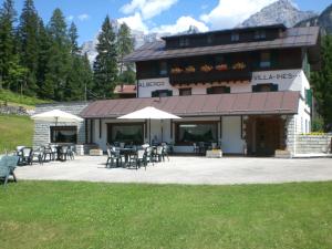 a building with tables and chairs in front of it at Hotel Villa Ines in Borca di Cadore