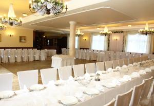 un salón de banquetes con mesas blancas y sillas blancas en Park Hotel, en Rzepin