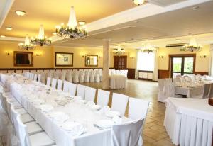 a banquet hall with white tables and white chairs at Park Hotel in Rzepin