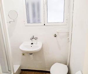łazienka z umywalką, toaletą i oknem w obiekcie Estudio Calle Murillo w Sewilli