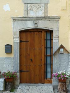 een houten deur aan de zijkant van een gebouw met bloemen bij Apartahotel Faure in Sallent de Gállego