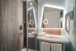 y baño con lavabo y ducha con espejo. en ibis Amboise, en Amboise