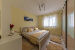 a small bedroom with a bed and a window at Apartment Danijela II in Šibenik