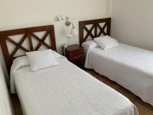 聖何塞的住宿－Santuario San José，一间卧室设有两张床,墙上配有一盏灯。