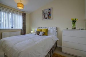 a bedroom with a large white bed and a dresser at Newly Renovated Modern Home in Manchester